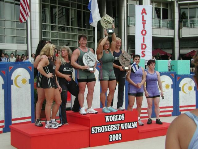 The strongest woman in the world, Jill Mills, proudly holds her award at the podium after winning the 2002 World's Strongest Woman Award.